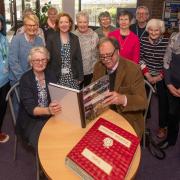 Members of Ainderby Steeple WI presenting their carefully crafted book to staff at Northallerton Library, where it will be on display during Local and Community History Month in May