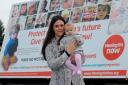 Claire Fox and her three-month-old daughter Jemima in front of the Meningitis Now billboard trailer