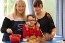 BAKE OFF: Marchbank pupil Alfie Vickers, eight, receives a helping hand from his nan Julia Spencer, left and his mum Lisa as they prepare cakes for a charity coffee morning