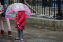 A child shelters under an umbrella. Picture: Daniel Leal-Olivas / PA Wire