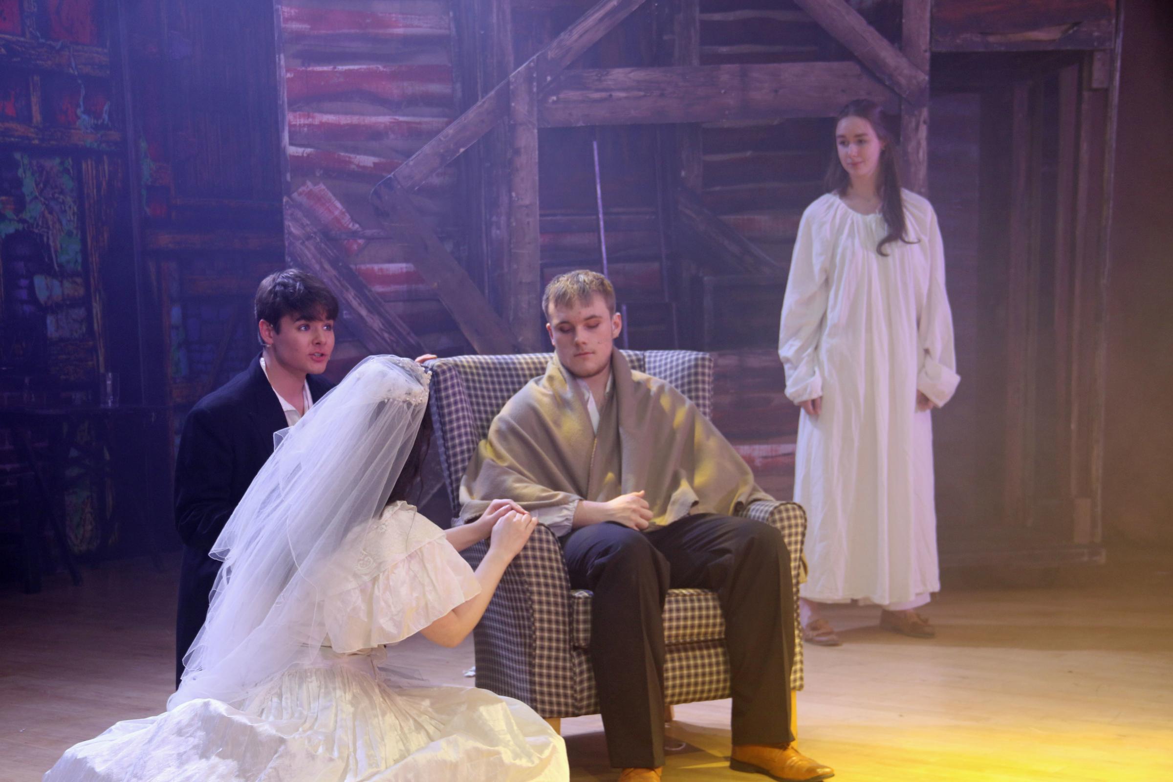 Valjean, played by Josh Hodgson, says his farewells to Cossette, played by Grace Robinson and Marius, Mathew Kerr, as the ghost of Fantine, Anna Forbes, watches on