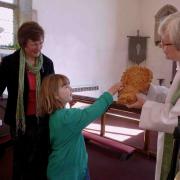 TEAM EFFORT: The Rev Sue Whitehouse examines the harvest bread made by Annabelle Spensley, six, and her grandmother, Anne Spensley