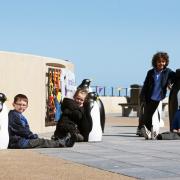 SEAFRONT FAVOURITES: From left, Connor Varley, Imogen Dixon, Max Harrison, Finn Winspur and Uziah Masvaure, all from Errington Primary School, welcome back the refurbished penguins on Redcar seafront.