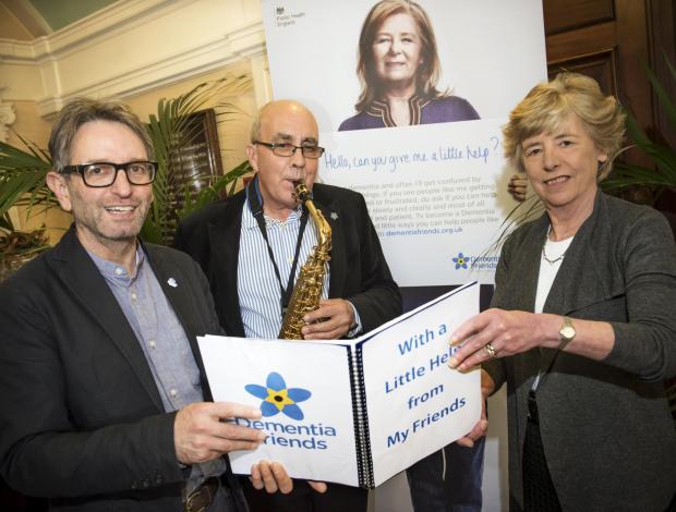 DEMENTIA FRIEND: Councillor Clare Wood and 600th Dementia Friend Martin Feekins listen to Chris Riley playing ‘With a little help from my friends’.