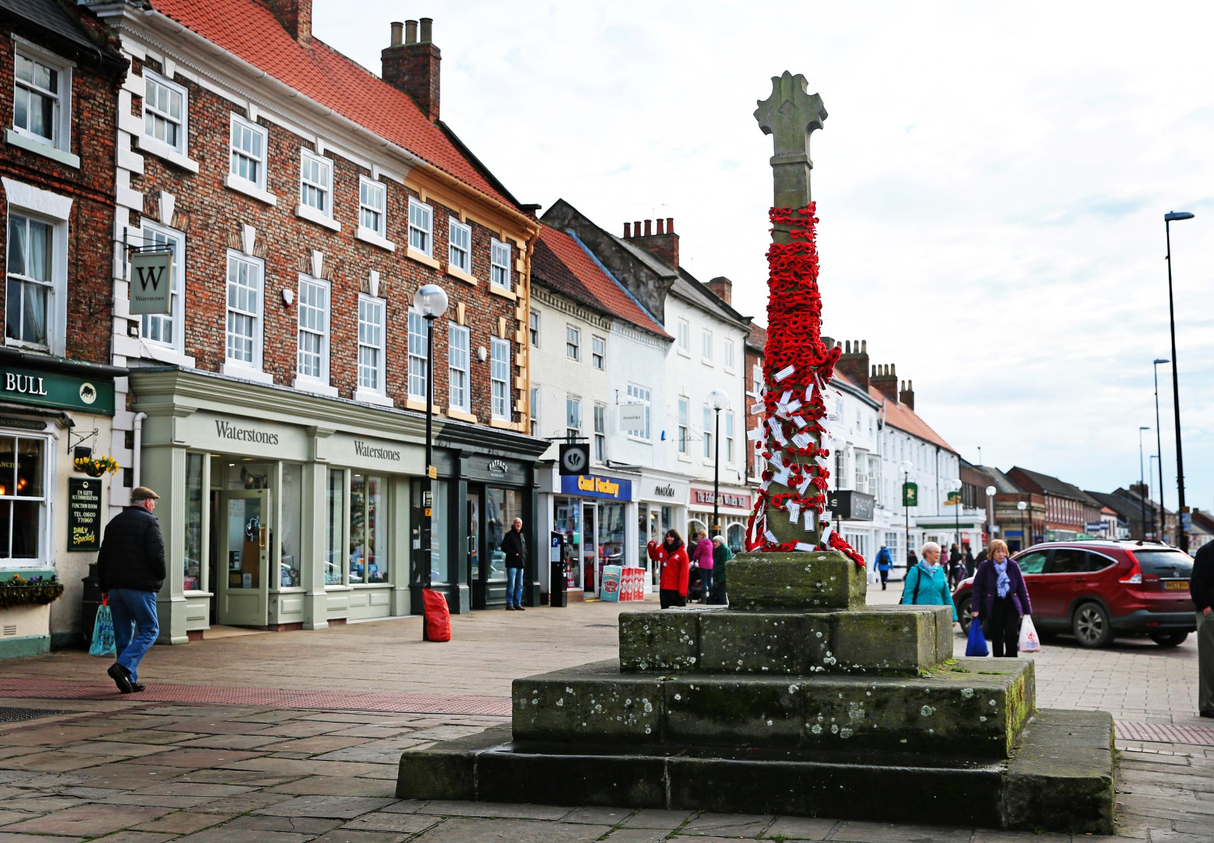The market cross outside the Black Bull in 2016 covered in poppies for Remembrance Sunday