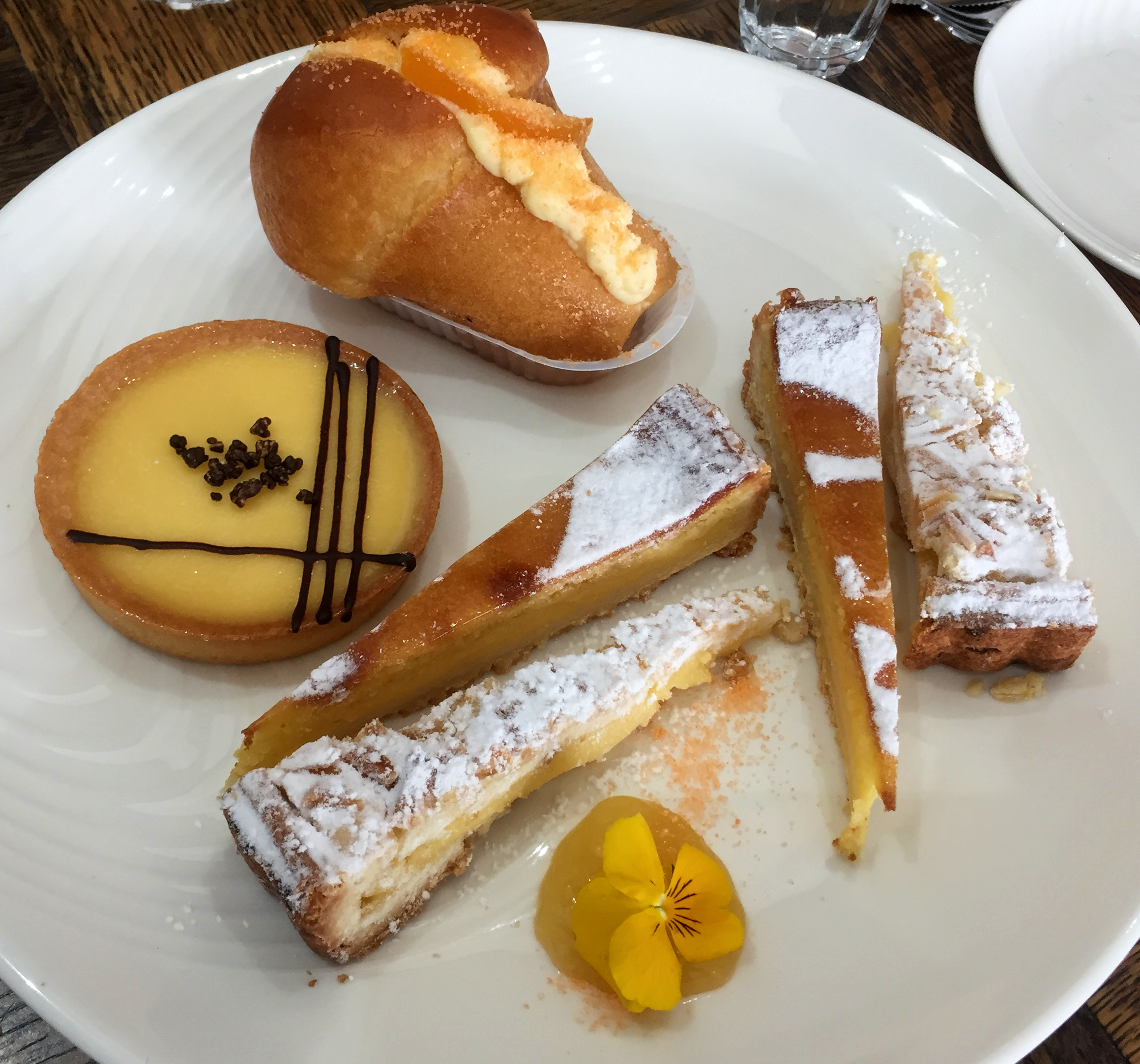 Our sharing plate of lemon-based desserts and a rum baba at the top