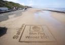 The 'Blue Flag Award' sand etching at Saltburn. Photograph by Stuart Boulton.