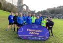 Bronwyn Mayo at Fountains Abbey having completed her 250th park run, with her group of supporters