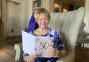 Joan Lawrence reads one of her cards as she celebrates her 80th birthday