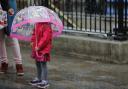 A child shelters under an umbrella. Picture: Daniel Leal-Olivas / PA Wire
