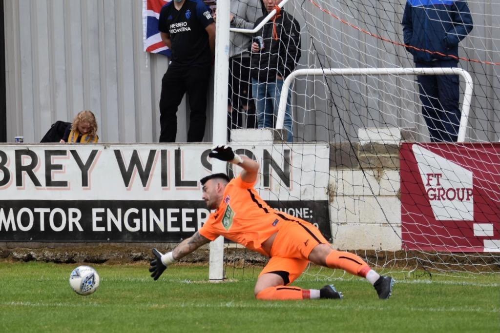 Guisborough goalkeeper Robert Dean dives to his right to push a goal-bound shot around the post