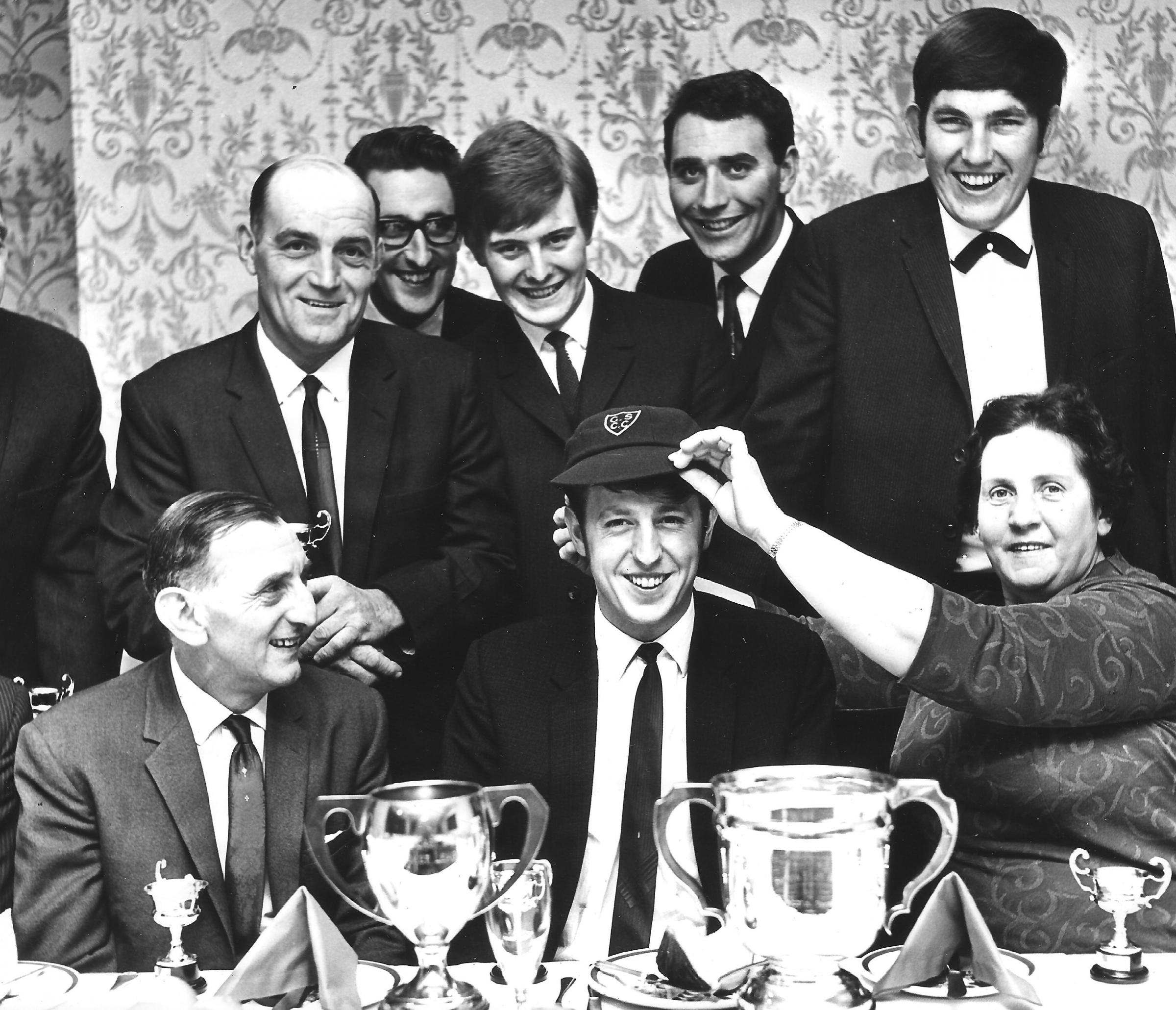 Ella Moody, whose late husband had been a stalwart of the cricket club, presents a club cap to Dennis Smith at an end of season ceremony in the late 1960s. Back row: Arthur Clark, Bill Haughton, Ian Dodsworth, Gilbert Turnbull and Jack Walker. Left on