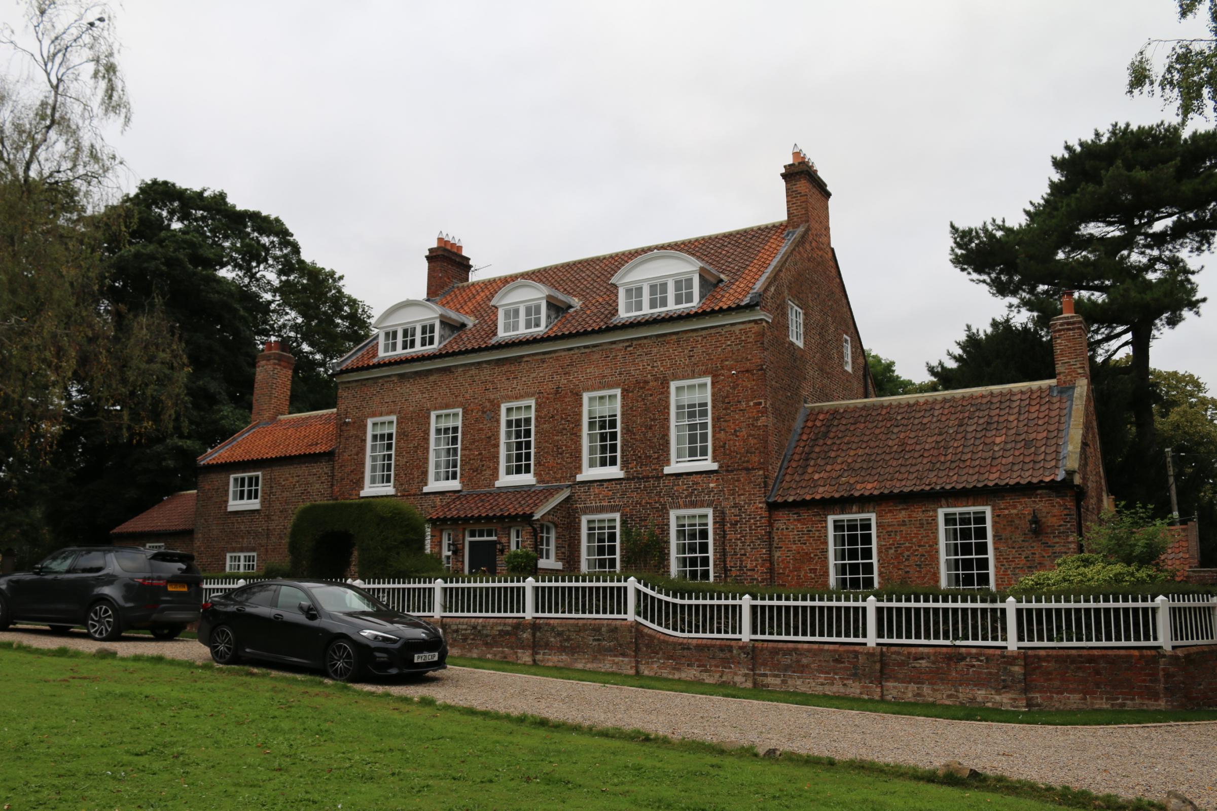East House, Great Smeaton: behind it is the cricket ground, and on its front is a Sun firemark