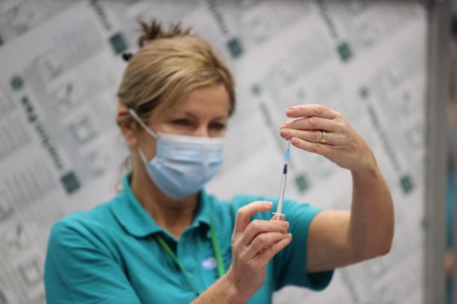 A vaccinator prepares vaccines at a Covid-19 booster vaccination centre