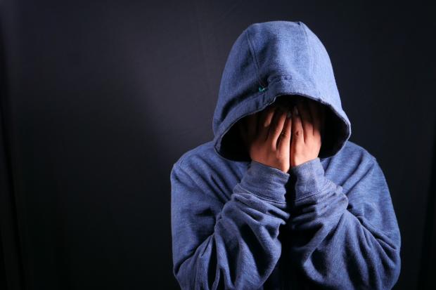 Darlington and Stockton Times: A person touching their face wearing a blue hoodie. Credit: Canva