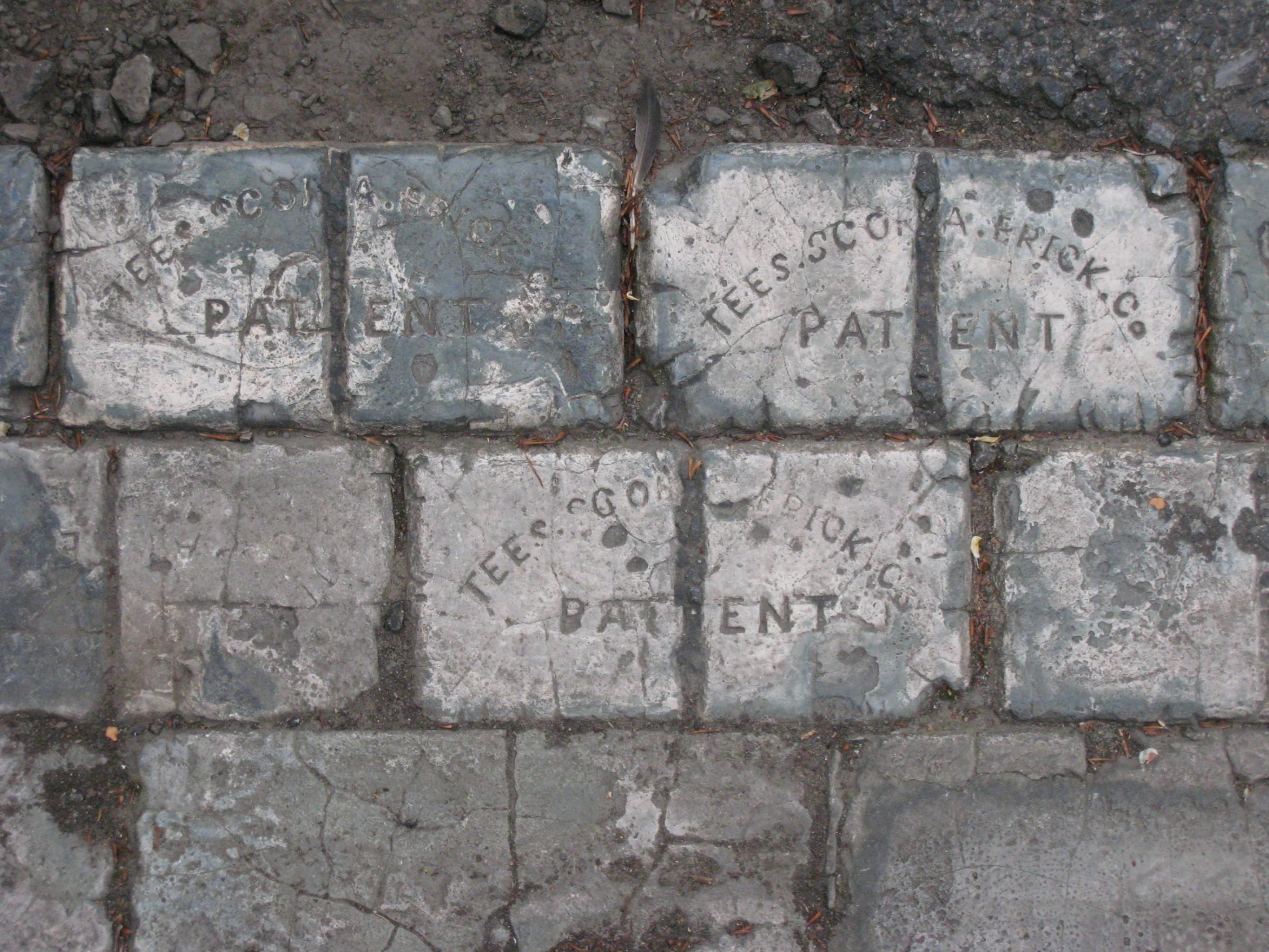 Scoria bricks in a gutter with the name of Joseph Woodwards company, the Tees Scoria Brick Company, pressed into them