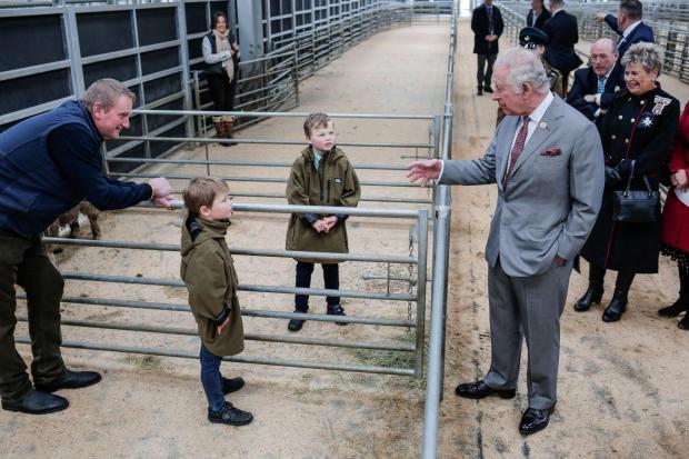 Darlington and Stockton Times: The prince of Wales was greeted by mart worker and farmer Stephen Dodsworth and his two sons Freddie, eight, and Patrick, six. Picture: STUART BOULTON
