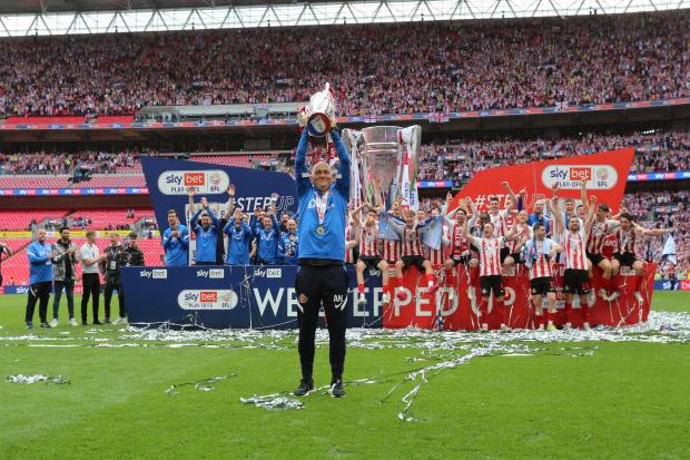 Alex Neil hoists the League One play-off trophy above his head at Wembley