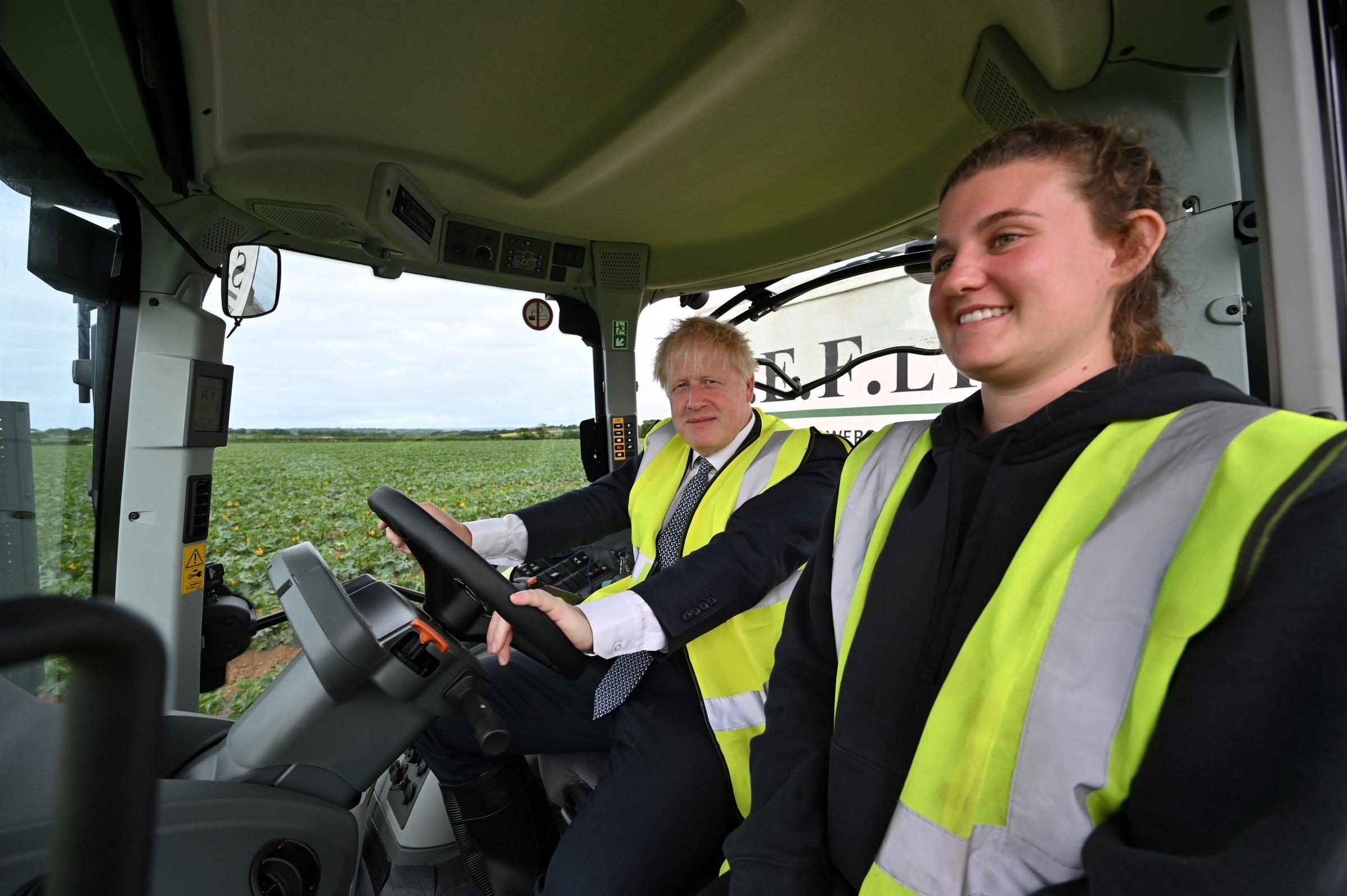 Prime Minister Boris Johnson drives a tractor during a visit to Southern England Farms Ltd in Hayle, Cornwall