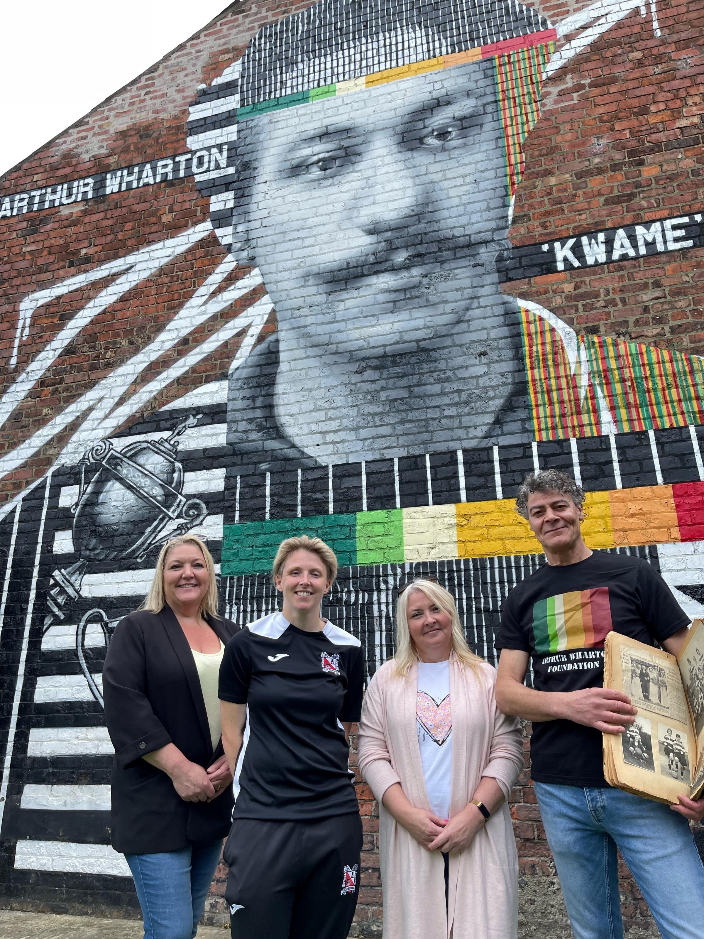 Beverley Avery, left, and her sister Gail Henderson, with Toni Upton, the current Darlington Ladies captain, and Shaun Campbell from the Arthur Wharton Foundation in front of the mural of Arthur in Widdowfield Street, Darlington
