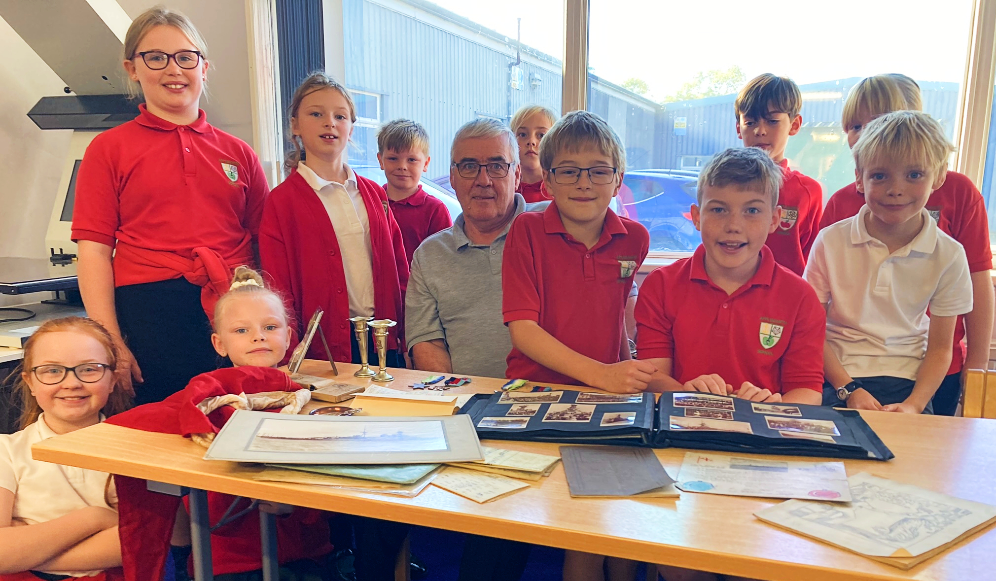 Barry Roberts, chairman of the HMS Hood Association, with some Year 5s from Applegarth Primary School at the North Yorkshire County Record Office on Monday surrounded by artefacts, pictures and plans relating to HMS Hood