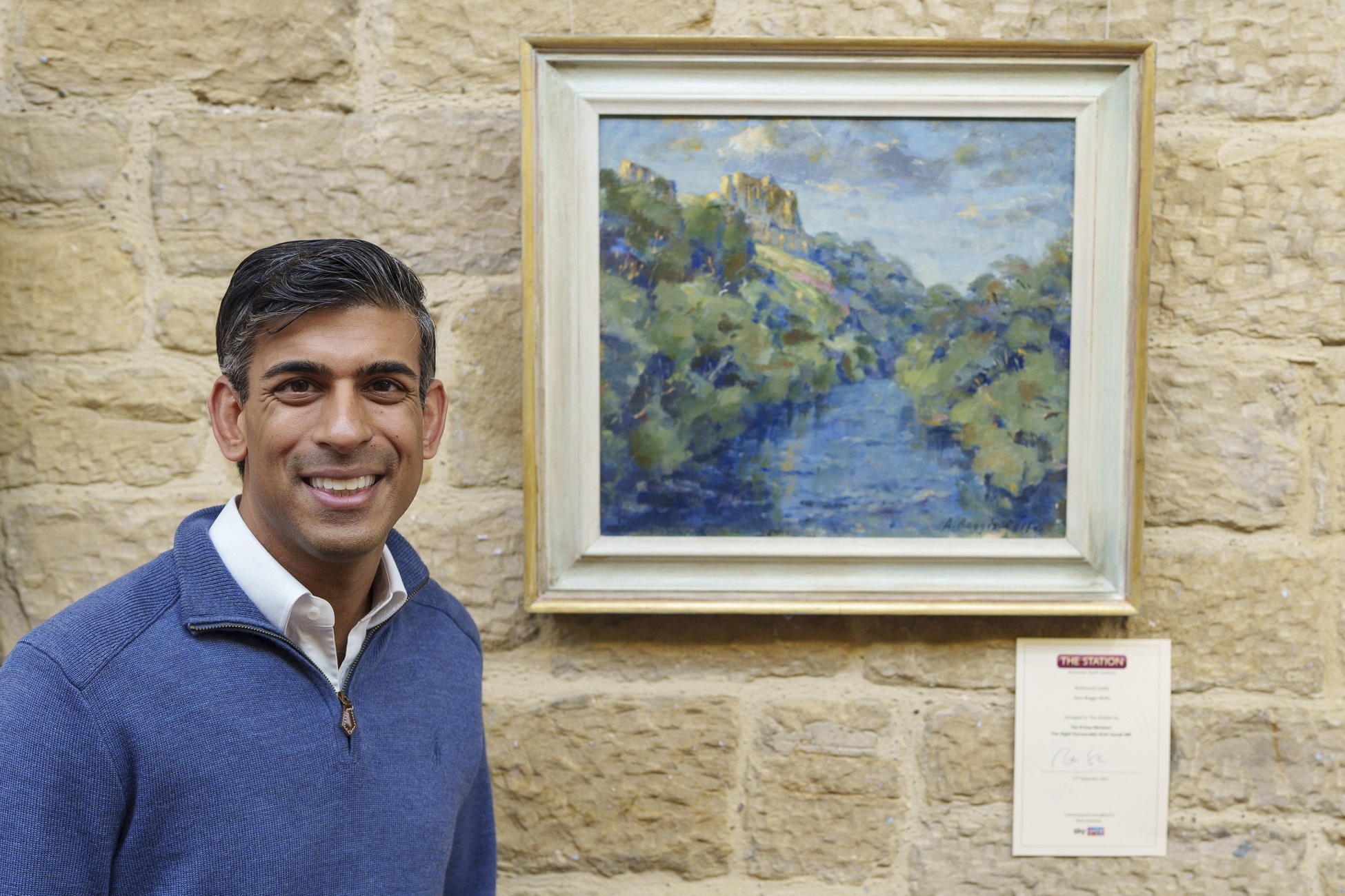 Rishi Sunak places a description of the work adjacent to Richmond Castle by Alice Boggis-Rolfe at the Spot on the Wall exhibition at The Station Gallery, Richmond