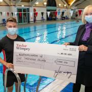 Joe Barron receiving a cheque from Taylor Wimpey's Jackie Prouse