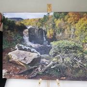 Martin Rogers with a large canvas print of one of his favourite images from the book