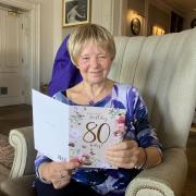 Joan Lawrence reads one of her cards as she celebrates her 80th birthday