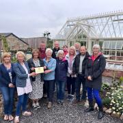 Dee Venner, county officer for the National Garden Scheme, presents a plaque to volunteers and supporters at Bellerby