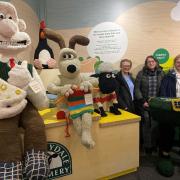 Wallace & Gromit in pride of place at the Wensleydale Creamery Visitor Centre with representatives from the Hawes Yarnbombers