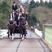 Owner Alex Bell (on the right) rides across  Aldwark Toll Bridge