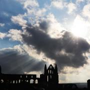 Rays of sunlight shine through Whitby Abbey – but do its bells still sometimes toll out at sea?